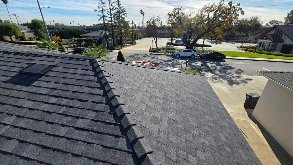 Finished dark architectural-shingle roof above a street.