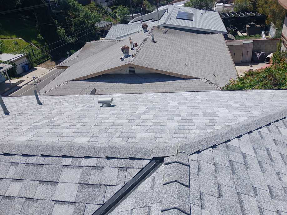 Finished light-gray architectural shingle roof planes.