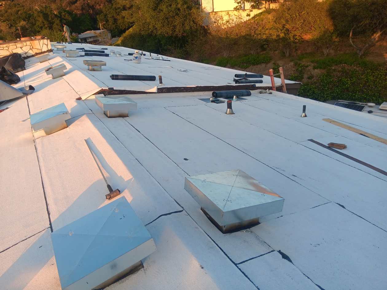 Broad white low-slope roof field with penetrations.