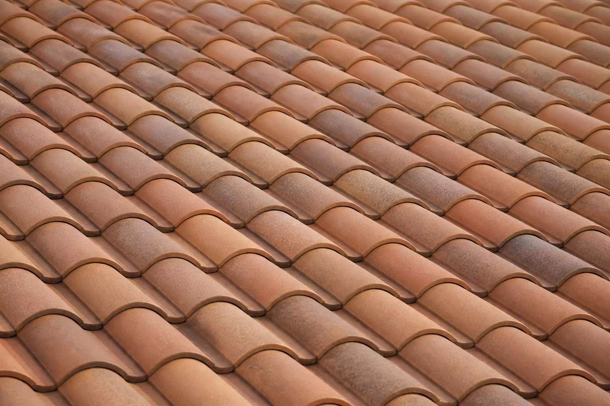 Muted terracotta S tiles across a finished roof plane.