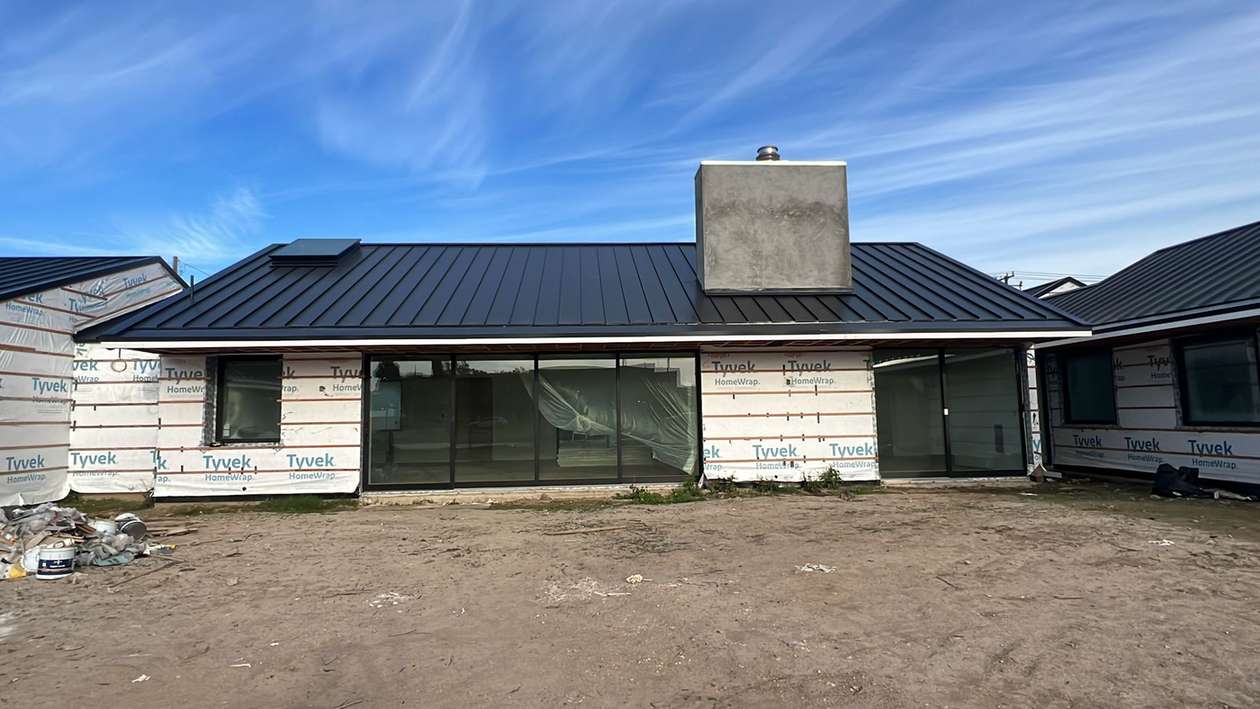 Finished standing-seam metal roof across a residential elevation.